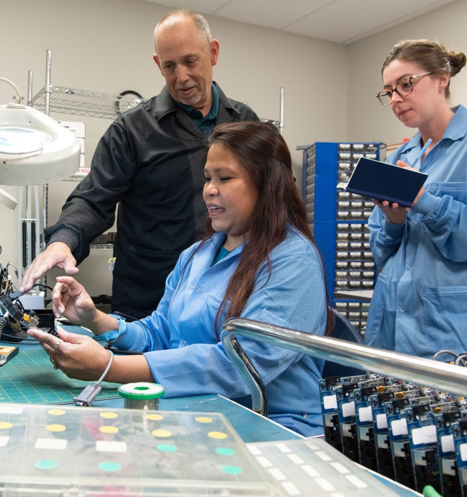 A PICA Manufacturing Solutions team member engaged in hands-on assembly, exemplifying the company's commitment to personalized service, expert engineering, and collaborative problem-solving in flexible and rigid-flex PCB production.