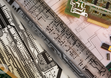 Cad drawings with printed circuit boards on a table.