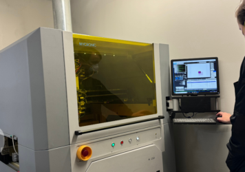 Operator standing next to a conformal coating machine